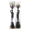 Par de grandes esculturas de bronze patinado, representando figuras masculinas segurando ânforas de onde saem candelabros, sobre bases do mesmo material, suporte para 09 lâmpadas cada. Alt. 216 x 42 x 38cm (total).Europa Início séc. XX