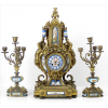 SEVRES (atribuído), Garniture de bronze, contendo par de candelabros e relógio, ricamente decorados com folhagens e detalhes laterais em forma de leões, relógio com figuras aladas encimadas por ânforas, placas de porcelana finamente esmaltadas. Alt. 38x15x16cm e 58x27x17cm, respectivamente. França,séc. XIX (uma delas falta placa lateral inferior)