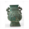 Vasilhame de bronze oriental arcaico, forma de pera, ricamente ornamentado com volutas em relevo, alças laterais estilizadas, design à maneira Dinastia Zhou (séc. 11/11 A.C.). Alt. 34 x 26 x 22cm.