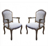 <p>Par de cadeiras de braços, madeira patinada e entalhada, estilo Luís XV, fina forração de tecido. Alt. 100 x 61 x 51cm. Europa, séc. XX</p>