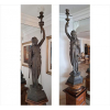 <p>Par de esculturas de petit-bronze representando figuras clássicas, com suporte para iluminação. Alt. 140 x 41 x 41cm. Europa, início séc. XX</p>