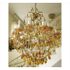 <p>Lustre com estrutura de bronze dourado, contendo 16 pontos de luz, ricamente decorado com pingentes dito amêndoas de cristal nas tonalidades âmbar e amarelo, parte central de cristal lapidado translúcido. Alt. 106 x 90cm. Europa Início séc. XX</p>
