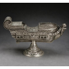 <p>Naveta de prata-de-lei sem contraste, representando forma de navio europeu, ricamente decorada com cinzelados, guirlandas e ramagens, parte frontal com carranca de leão estilizado. Alt. 16 x 28 x 09cm. Brasil Séc. XVIII</p>