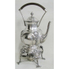 Samovar em prata, teor 833 milésimos, com cinzelados em conchas, flores, folhas, volutas e perolados. Pés curvos. Alça com madeira. Alt. 34cm. Peso total 1125g. 