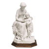 Belíssimo grupo escultórico em biscuit europeu, possivelmente alemão, representando Mãe com seu filho. Base em madeira dourada e entalhada. Med. 34x17,5x16cm.