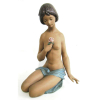 Lladró - estatueta em porcelana espanhola policromada, representando Menina semidesnuda, estando esta sentada sobre as pernas. Alt. 46,5cm.
