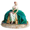 Guido Cacciapuoti (1892-1953) - Escultura art-deco, em porcelana italiana policromada, representando Dama com flores. Med. 35x45,5x30,5cm.