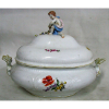 Belíssima sopeira em porcelana alemã, marca da manufatura de Meissen, com trabalhos em relevo e pintura floral em policromia. Pegador da tampa na forma de Puttino. (pescoço do Puttino colado). Med. 30,5x38x24cm. 