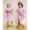 Belo par de estatuetas em biscuit europeu, policromado, representado Casal de crianças. Alts. 29 e 22,5 cm.