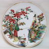 Raro e belo prato em porcelana oriental, decorado com pintura esmaltada de cena do cotidiano no jardim em policromia. Apresenta inscrições e assinatura no verso. Diam. 25cm. 