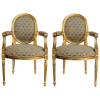Par de poltronas, estilo Luís XVI, em madeira dourada e entalhada. Encosto, assento e braçadeiras estofadas e forradas em tecido. Em perfeito estado. Med. 96x53x57cm.