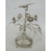Paliteiro em prata brasileira, na forma de vaso sobre salva, com galho de flores e folhas, estando sobre estas, pássaro em pouso. Pés em pata. Alt. 22,5cm.