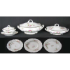 Aparelho de jantar em porcelana francesa, marca da manufatura Limoges, com pintura floral em policromia e detalhes em dourado, composto de sopeira, 5 travessas, molheira, terrina com tampa, saladeira, 27 pratos rasos, 16 fundos e 10 para sobremesa. (5 pratos rasos, 5 fundos, 1 de sobremesa, legumeira e 2 travessas com pequeno bicado). Total de 62 peças.