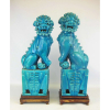 Par de grandes estatuetas em faiança esmaltada na cor azul, representando Casal de cães fó estando um com seu filhote. Base em madeira. Alt. total 51,5 cm.