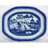 Antiga travessa de coleção em porcelana de Macau, decorada com cena de paisagem com pagodes em azul. Borda com pequenos bicados. Med. 33,5x26,5 cm.