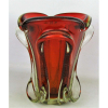 Belo vaso em grosso Murano italiano, dos anos 50, no tom doublet cereja e translúcido, lapidado em gomos recurvos em relevo e decorado internamente com minúsculas bolhas de ar. Borda ondulada e com recortes. Alt. 26,5cm.