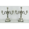 Par de candelabros para 3 velas em prata contrastada, e com marca do teor 835 milésimos. Decorado com cinzelados em folhas e volutas. Pés em pata. Med. 33,5x30,5x13cm. Peso 2685g.
