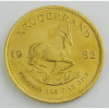 Moeda de coleção, em ouro fino, tendo no anverso busto com os dizeres Suld-Afrik-South Africa, e no verso, figura de cervo com os dizeres Krugerrand-1982-Fyn-goud-10z. Fine gold. Peso 33,9 g. Este item não se encontra no local do leilão.