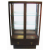 Bela vitrine art-deco, em madeira nobre, formada por 2 portas de abrir com 2 prateleiras no interior e iluminação funcionando. Portas e laterais com vidros bisotados. Parte inferior com 2 gavetas. Puxadores em bronze. Med. 158,5x93x40cm.