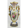 Grande vaso com alças em porcelana Vieux Paris, decorado com pintura de flores e folhas em policromia. Detalhes em azul e dourado. Pequenas perdas no dourado e uma pequena quebra no corpo próximo a base. Alt. 52,5cm.