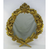 Belo espelho de parede, com imponente moldura em madeira entalhada e patinada de dourado, decorada com ricos entalhes de folhas e flores. Patina com pequenas perdas. Med. 92x77,5 cm.