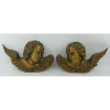 Par de esculturas de pendurar, em madeira nobre entalhada e patinada de dourado, representando Cabeça de anjo. Med. 20x33x10cm.
