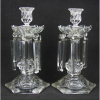 Baccarat - Par de belos castiçais em grosso cristal francês. Bases sextavadas. Coluna central com lapidações dedão. Pingentes em cristal lapidado, sendo dois diferentes e falta um pingente. Apresentam discretos bicadinhos. Alt. 28,5cm.