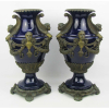 Belo par de vasos em porcelana europeia, na cor azul cobalto. Guarnições em bronze ricamente trabalhadas com folhas, volutas, guirlandas, cachos de uva, bustos femininos com asas e cabeças de figuras. Alts. 42cm.