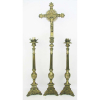 Arte sacra - Belo terno para altar em bronze, composto de grande Crucifixo com Cristo vivo e par de castiçais. Peças trabalhadas em gomos, volutas e folhagens, com bases triangulares tendo em cada face figura sacra em relevo. Alt. castiçais 58cm e alt. Crucifixo 93cm.