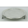 Antiga esmoleira circular em prata baixa, com três pés trabalhados em gomos. Borda decorada com frisos, com pequenas mossas e pequena fissura. Diam. 23cm. Peso 455g.
