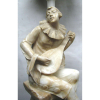 Escola Italiana - Excepcional luminária em alabastro representando -Pierrot tocando música sentado sobre rocha-.Alt. 77,5 cm.