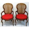 Elegante par de antigas cadeiras de braços, em jacarandá, entalhado. Pernas recurvas. Assento e encosto em palhinha. Med. 109x61x54cm.