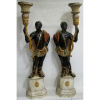 Par de antigos e belos Black-Amour venezianos, em madeira com patina policromada, representando figuras masculinas sustentando tochas com floreira. Base na forma de colunas gregas. Alts. 141cm. Base: R$ 7.000,00 