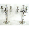 Belo par de candelabros, reversível para castiçal, para 4 velas, em prata inglesa, contraste de Sheffield de 1915 e do prateiro H.E. Ltda., formado por 3 braços recurvos e bobeche central. Med. 39x24x24cm. (na parte mais fina do corpo, de um deles, apresenta rachado, sendo necessário fazer um reparo).