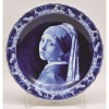 Belíssimo medalhão decorativo em porcelana holandesa, de Delft, nos tons deazul e branco, com pintura tema de um dos mais famosos quadros de Vermeer é tema da porcelana de Delft, terra natal do pintor. Aba com flores. Borda em ondulações . Diam.41,5cm