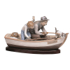 Lladró - Grupo escultórico em porcelana espanhola policromada, representando Canoa com avô e neto pescando. A canoa é intitulada Paloma. Base de madeira. Med. 19,5x40x15cm.