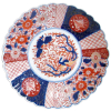 Antigo medalhão em porcelana Imari, com pintura em policromia. Borda ondulada. Diam. 31cm.