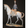 Lladró - Escultura em porcelana espanhola policromada, representando Dama a cavalo. (apresenta 2 pequenos pontos com pequena perda no esmalte). Med. 43x34x11cm.
