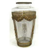 Belo e grande vaso em cristal europeu, lapidado em frisos bisotados. Guarnições em metal ormulú, banhado de dourado. Alt. 39,5cm.