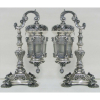 Belo par de luminárias, estilo D. João V, na forma de lampiões, em prata cinzelada em conchas, flores e volutas. (falta um vidrinho). Alt. 27,5cm. Peso total 3.200kg.