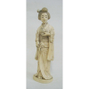 Okimono em marfim, representando Dama no jardim. Japão, Época Meiji. Assinado na base. Alt. 20cm.