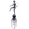 G. Mandarino - escultura em bronze representando Dançarina com círculo, estando esta sobre um globo. Alt. total 97cm. Acompanha coluna em fer forge com tampo em mármore. Alt. 60cm. 