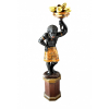 BLACKAMOOR VENEZIANO <br />ESCULTURA EM MADEIRA ENTALHADA, CARNADA E POLICROMADA.<br />MENINO ESCRAVO, SEGURANDO CORNUCÓPIA COM FRUTAS (Símbolo de fartura).<br />BASE SEXTAVADA, ARRANJO DE FRUTAS EM METAL DOURADO REBATIDO A MÃO.<br />ITÁLIA, SÉCULO XIX.<br />MEDIDAS da peça: 105cm x 47cm x 35cm.<br />MEDIDAS da base: 44cm x 32cm x 32cm. <br /><br />Entre os séculos XVII e XVIII, figuras em madeira laqueadas e douradas aparecem no mobiliário veneziano, como prateleiras, pedestais, porta-vasos.<br /><br />A figura do servidor que sustenta tampos, vasos, almofadas é muitas vezes a do Moro, personagem desde o século XVI ligado à imagem de Veneza.<br /><br />O Moro, portanto, já aparece no gabinete que Vittore Carpaccio pintou, em 1490, para a família Moncenigo e também apareceu nas grandes telas da Última Ceia e das Bodas de Caná pintadas pelos Mestres Venezianos da século seguinte.<br /><br />Eram representados, no século XVIII vestidos à moda oriental, ou com ricos mantos de seda entrelaçados com ouro, com ricos saiotes e cocares imaginativos. Assim encantando a moda, ordenado uma tradição que há muito foi usada.