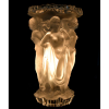René Lalique (French, 1860–1945)<br />'Bacchantes' vase, 1927<br />24,5 X 15 X 15 CM.<br /><br />René Jules Lalique (Ay, 6 de abril de 1860 – Paris, 1 de maio de 1945) <br />Ficou bastante conhecido por suas criações em joias, frascos de perfume, copos, no estilo Art nouveau e Art déco<br />Aos 16 anos, René se tornou aprendiz do ourives Louis Aucoc, em Paris, estudou na Ecole des Arts Décoratifs de Paris e em Londres no Sydenham Art College, onde trabalhou com ourivesaria aprendida com Aucoc.<br />Em seu retorno da Inglaterra, trabalhou como freelance para joalherias como Boucheron e Cartier até, em 1886, abrir sua própria joalheria.<br />Em 1890, já era reconhecido como um dos joalheiros de Art Nouveau mais importantes de França.<br />René foi o primeiro a esculpir em vidro para obras monumentais e criou frascos de perfume em vidro, sendo assim o primeiro a imaginar a comercialização de um produto de luxo com o refinamento de uma embalagem igualmente delicada e, patentou diversos processos novos de fabricação de vidro como o satinado Lalique ou o vidro opalescente. <br />Em 1925 haveria uma exposição mundial, da qual René participou, com um grande pavilhão adornado com uma fonte em vidro de 14m de altura. <br />Foi o responsável pelas decorações em vidro do Expresso do Oriente e seu vagão presidencial, da Galeries Lafayette, em Paris, do Palácio Imperial do Príncipe Asaka e inumeros outros locais.<br /><br /><br />