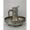 ORFÈVRERIE GALLIA - CHRISTOFLLE - FRANCE. <br />Conjunto de Gomil (Jarra e bacia) para toilette.<br />Estilo e época ART NOUVEAU (1890-1914)<br />Em PEWTER com rico trabalho e desenhos em alto relevo de motivos florais.<br />Med: 35 x 41 cm de diametro na borda da bacia.<br /><br />CHRISTOFLLE - GALLIA (...) Um de seus passos mais importantes foi a criação da linha Gallia. Este nome de marca registrada aplicado a uma nova liga, semelhante ao estanho, mas mais durável, o metal Gallia era ideal para fundição e menos caro para fabricar e chapar (...)<br />FONTE: https://www.925-1000.com/a_christofle.html