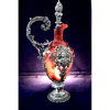 WMF (Württembergische Metallwarenfabrik)- Art Nouveau (1890-1910) <br />CLARET JUG, Bojo em cristal soprado tonalidade Ruby. Nas reservas, um cupido segura cálice. <br />Peça semelhante reproduzida livro da manufatura de 1906, página 133. Marca conforme fotos em anexo. <br />Recipiente original em cristal.<br />Medidas: 28 x 13 x 10 cm.<br />