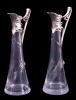 WMF (Württembergische Metallwarenfabrik)- Art Nouveau (1890-1910)<br />Par de jarras CLARET JUG em estanho e cristal lapidado.<br />Peças similares reproduzidas no livro da manufatura, de 1906, página 142.<br />Medidas: 25,5 x 8 x 10 cm.