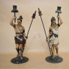 PAR DE CANDELABROS EM PEWTER POLICROMADO- GUERREIROS, C.1890.<br />38x13x13 cm.<br /><br />EGIPTYAN REVIVAL -  As descobertas arqueológicas no Egito no FINAL DO SÉCULO XIX, geraram uma rica veia de inspiração artística que alimentou a ART NOUVEAU e o movimento ART DECO, subsequente,com ideias e estilos distintos,culminando nas décadas 1920 e 30. <br />A EGIPTOMANIAevoluiu com o surgimento da Enciclopédia L’ÉGYPTE ,de 20 volumes 1827, resultado de um grande contingente de mais de 500 estudiosos, <br />incluindo cientistas e artistas. Reforçado pela exibição de peças reais de arte egípcia nos museus da Europa e a descoberta da TUMBA DO REI TUTS em 1922.<br />Uma nova onda de interesse nos mistérios do renascimento e outros mitos egípcios, levando a uma ampla exposição emBelas Artes, literatura, moda e cinema .<br />Uma estética egípcia altamente estilizada convergiu perfeitamente com os designs Art Déco, adornando a arquitetura, móveis e outras artes decorativas com representações de motivos espirituais, botânicos e geométricos. Hieróglifos, flores de lótus, flores de papiro, escaravelhos, deuses e deusas egípcios, discos alados e a maioria dos símbolos egípcios antigos populares estavam representados. Objetos como relógios, cigarros e caixas de toucador, vasos e joias foram interpretados usando cores que refletiam as escolhas usadas durante a era egípcia faraônica.<br />https://www.veniceclayartists.com/exotic-egyptian-art-deco/