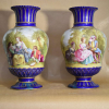 SÉVRES - FRANÇA SÉCULO XIX.<br />PORCELANA, PAR DE VASOS COM PINTURAS DE CENAS GALANTES NO FRONTÃO E CHATEAUS NO VERSO.<br />DUAS CENAS DISTINTAS.<br />FUNDO AZUL COBALTO E OURO.<br />55X33X33 CM.<br />