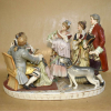 Grupo escultórico figurando cena familiar da nobreza no século XVIII, apresentação de bebê. Porcelana pintada à mão, manufatura CAPODIMONTI, NÁPOLIS desde 1743. <br />Peso: 3.600 g. Medidas:26 x 33 x 20 cm. 